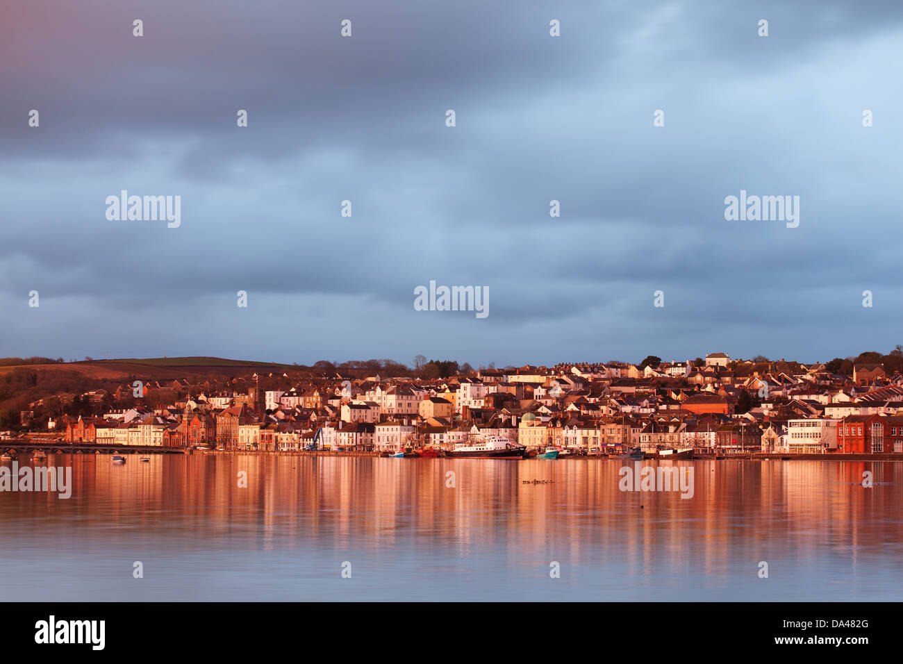 View across estuary at high tide towards town with rainclouds gathering
