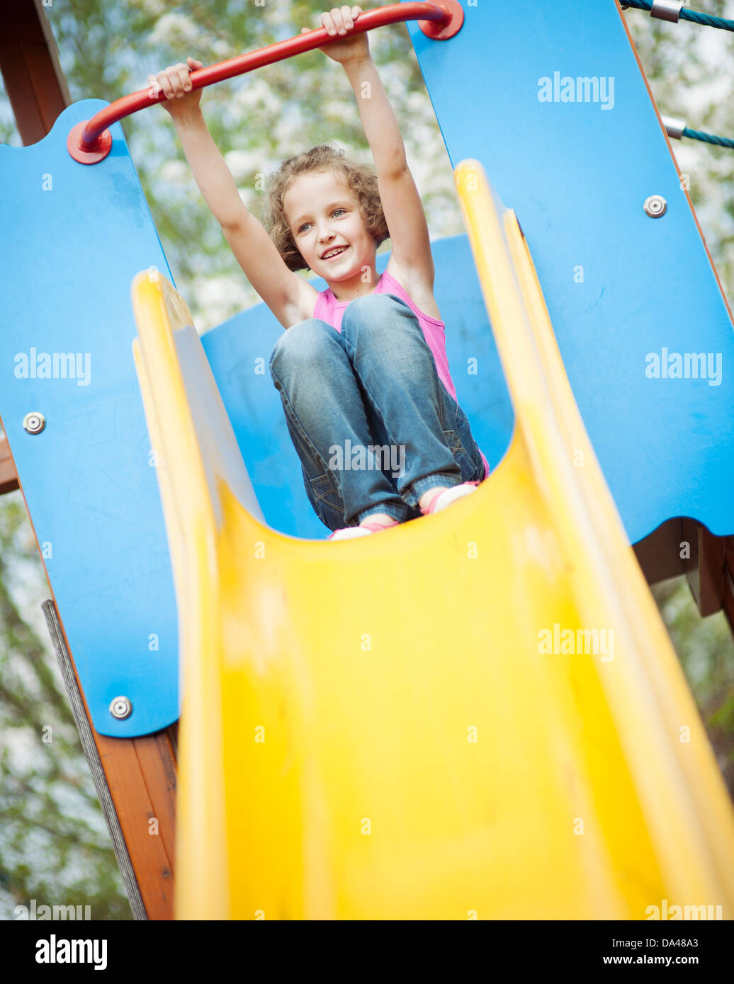 Young girl on slide in playground Stock Photo - Alamy