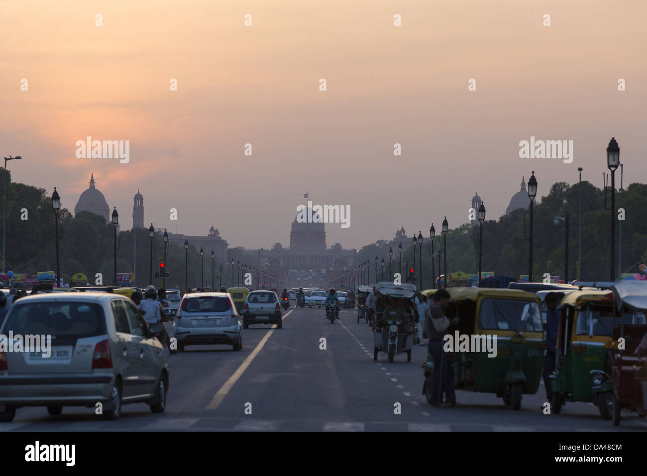 View of road with traffic and government buildings at dusk, New Delhi, Delhi, India, March Stock Photo