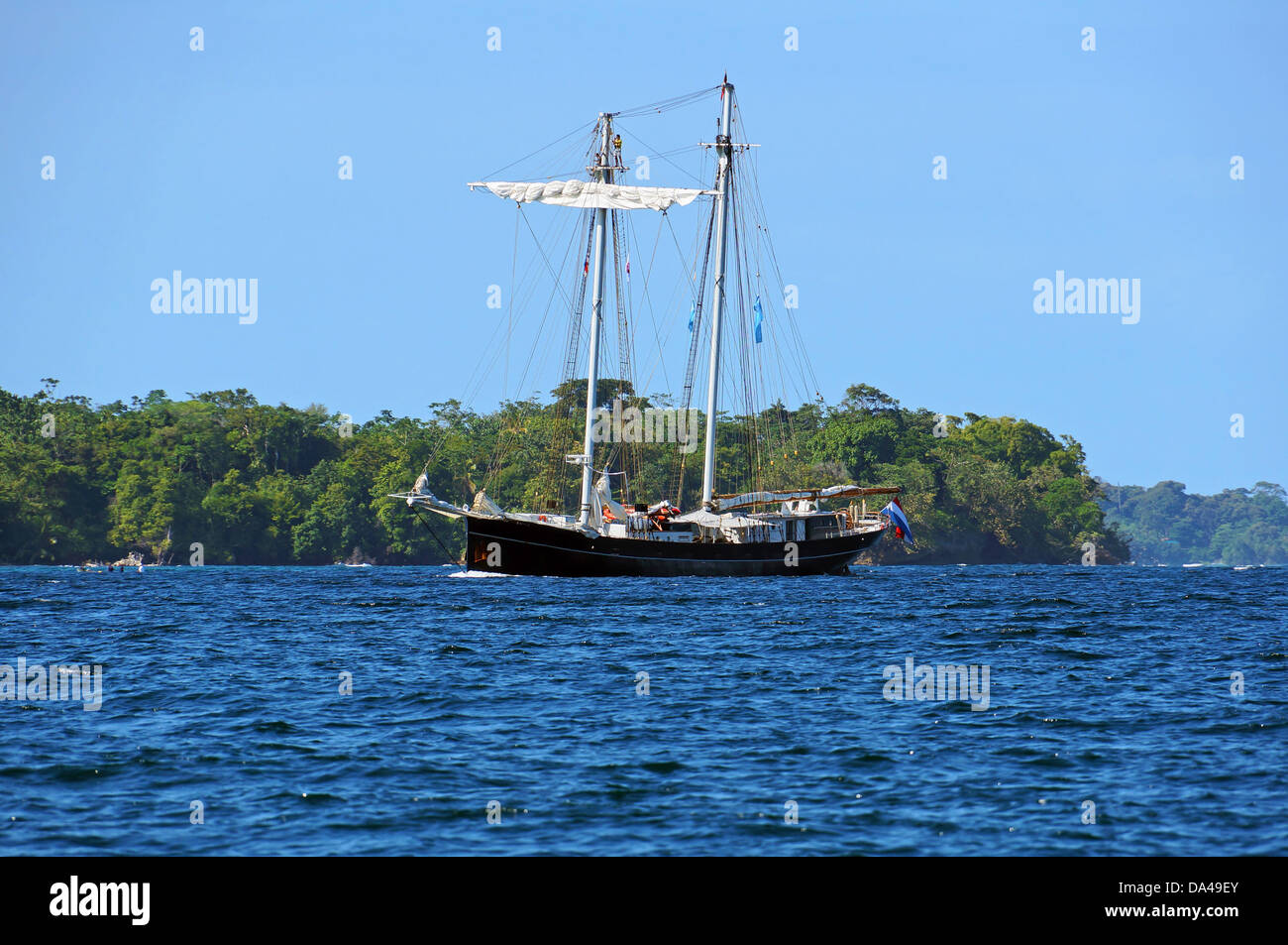 Beautiful sailing ship with a tropical island in background, Bocas del Toro, Panama Stock Photo