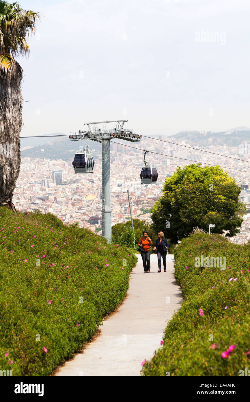 Tourists walking under Montjuic cable car tower Barcelona panorama ...