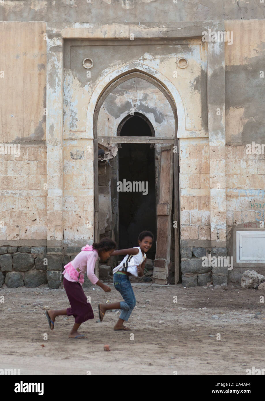 Girls Running In Front Of An Ottoman Door, Massawa, Eritrea Stock Photo