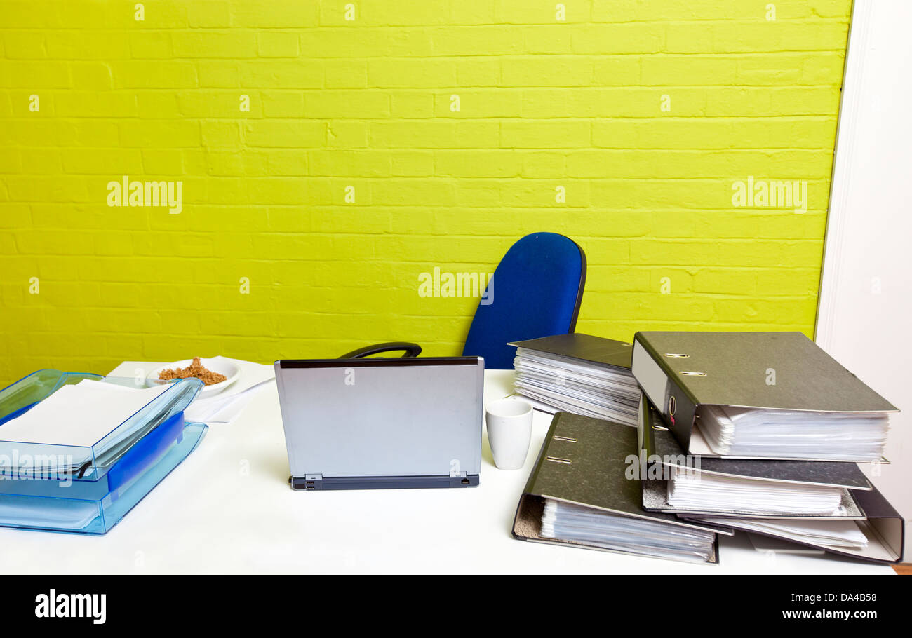 Vacant desk with laptop, folders and empty chair Stock Photo