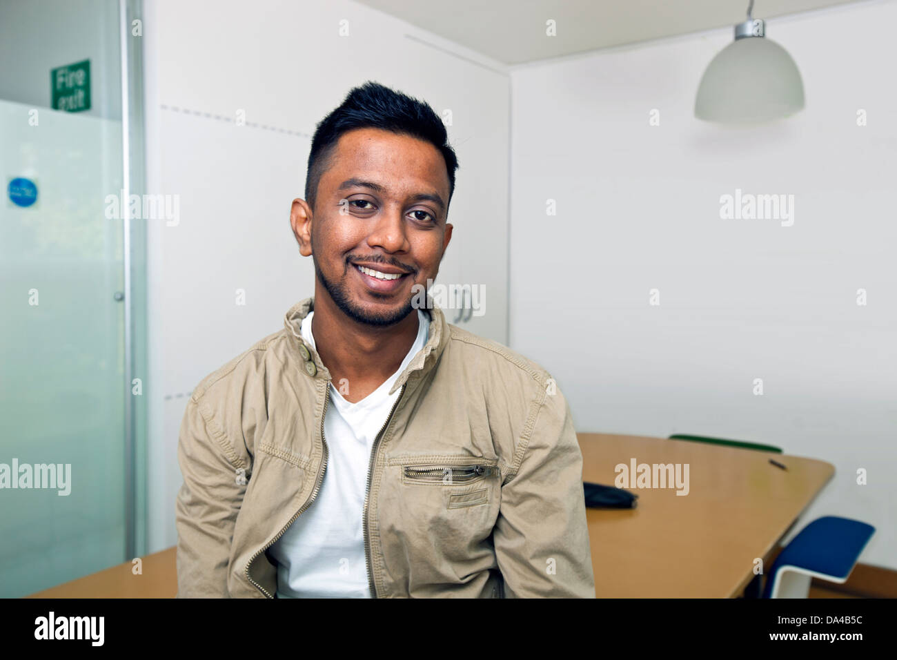 Young Indian man smiling at camera in his office Stock Photo