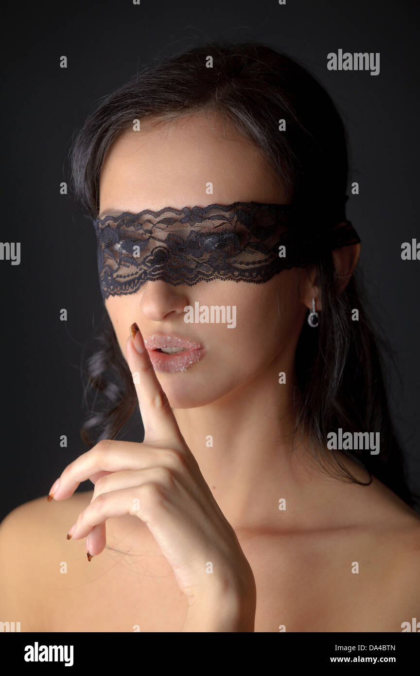 Portrait of young attractive brunnete woman with sugar on her lips holding her finger near lips Stock Photo