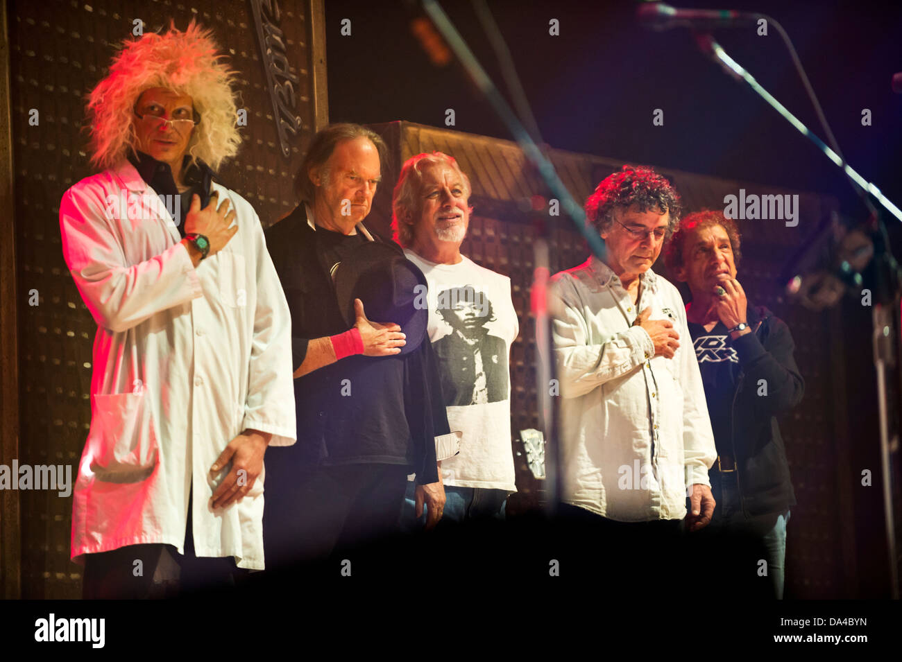 Neil Young and Crazy Horse with 'mad scientist' roadie, stand for God Save the Queen at the NEC Birmingham UK, 11 June 2013 Stock Photo