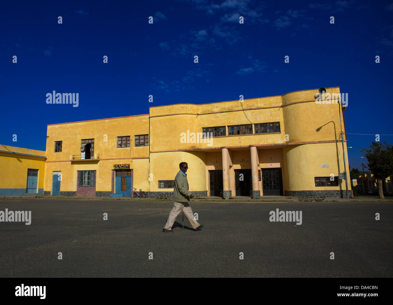 Man Passing In Front Of An Old Colonial Italian Cinema Theatre, Dekemhare, Eritrea Stock Photo