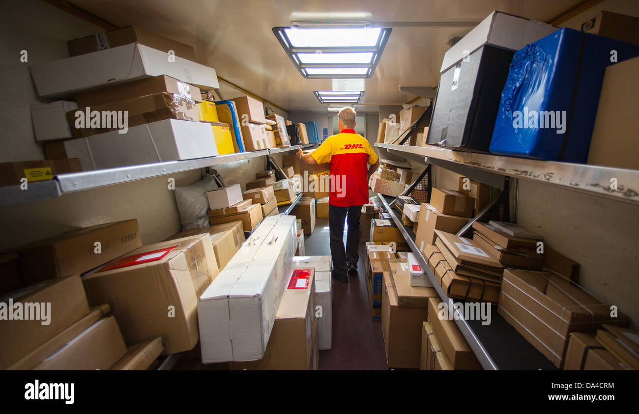 A member of staff of the Deutsche Post DHL shipping service loads his delivery truck with parcels at the newly opened shipping hub of DHL in Berlin, Germany, 3 July 2013. The facility has the capacity to process up to 8000 packages and parcels a day. Photo: Hannibal Hanschke Stock Photo