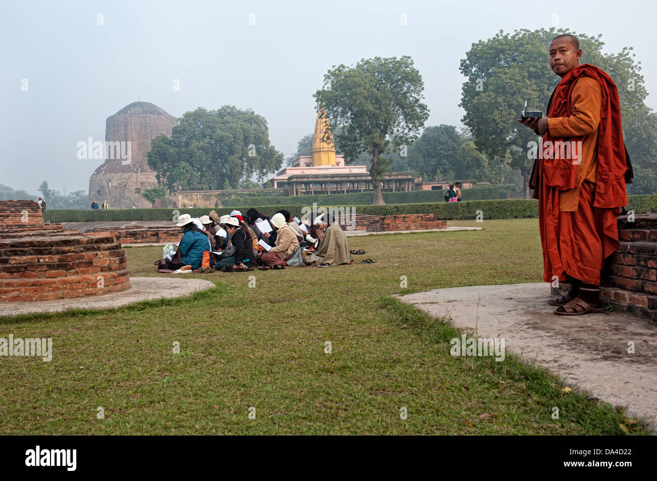 Monk and pilgrims in Dhamekh, temple. Sarnath, Uttar Pradesh, India Stock Photo