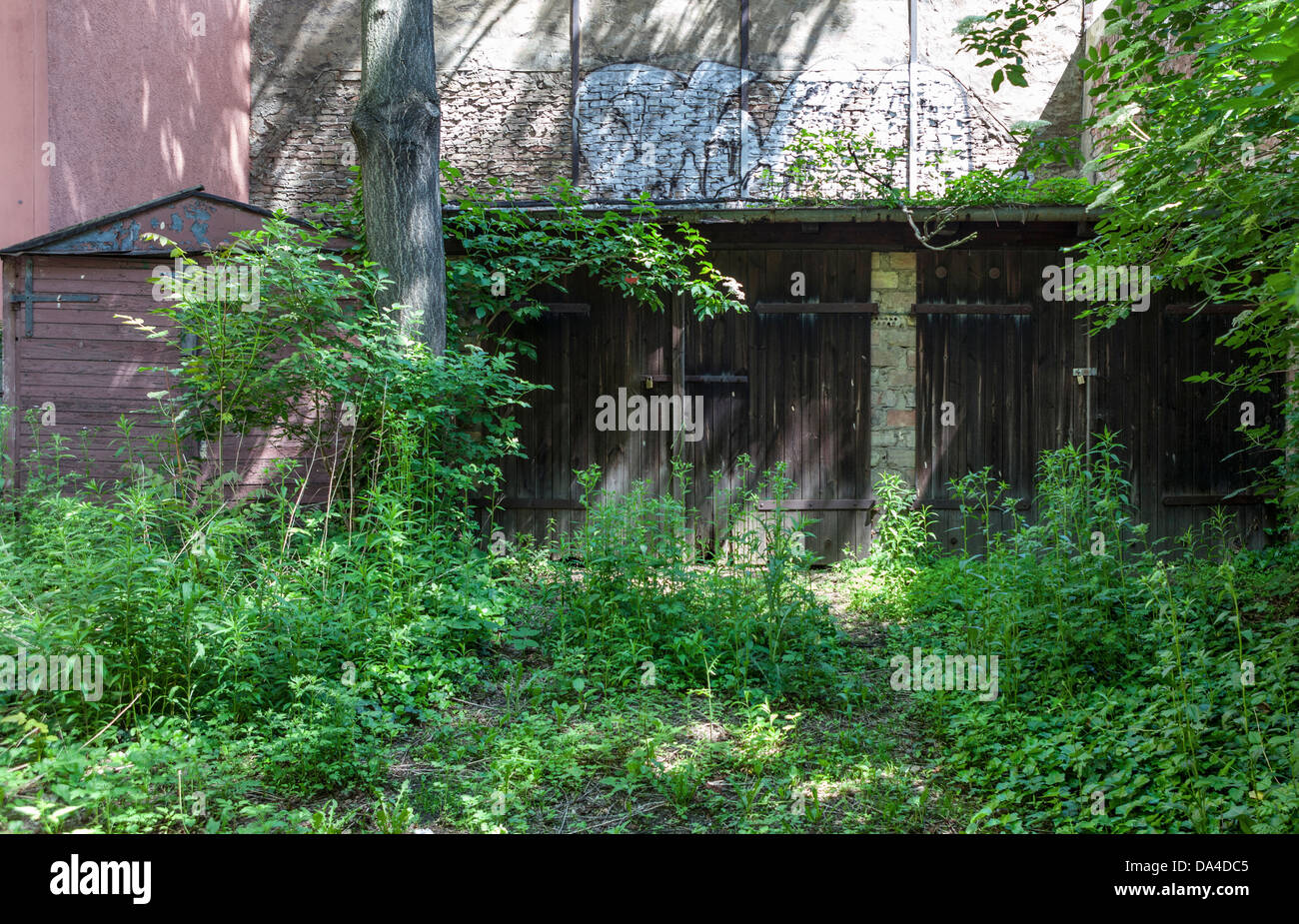 Urban decay - Dilapidated shed and garage doors in the inner courtyard of aBerlin building Stock Photo