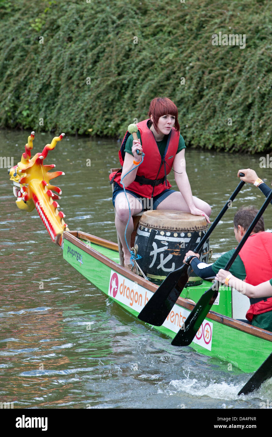 A female drummer on a Dragon Boat. The race was started by Dame Kelly Holmes, on the River Medway in Tonbridge, Kent, UK Stock Photo