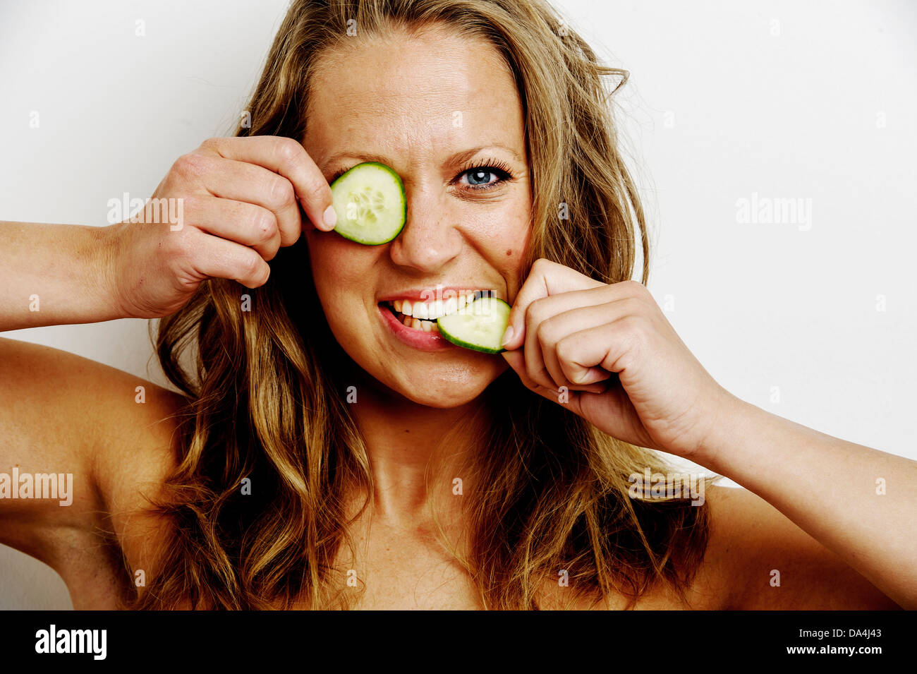 A young woman holding cucumber slice over her eyes Stock Photo Alamy