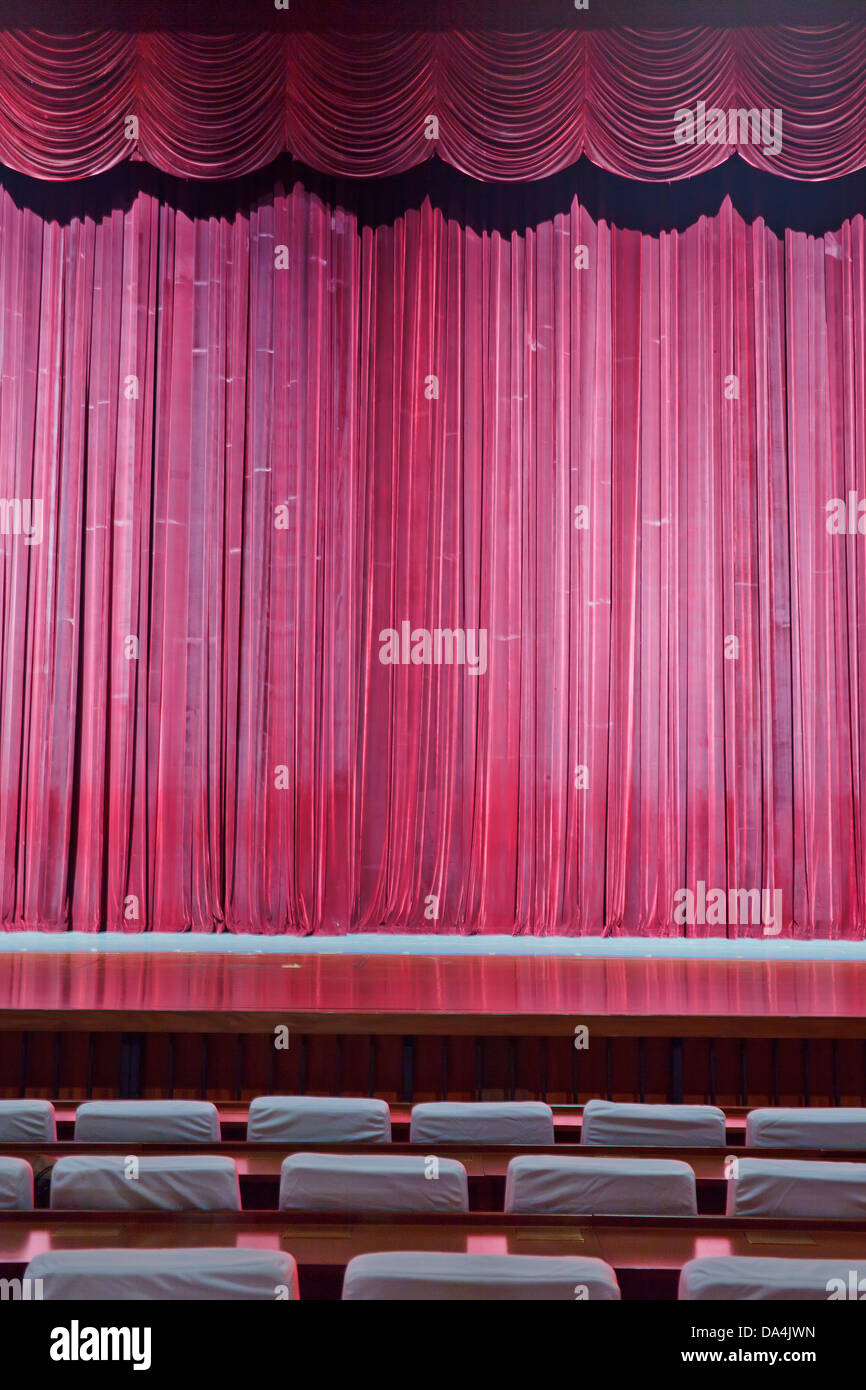 Pleated, red, hanging fabric stage curtain Stock Photo