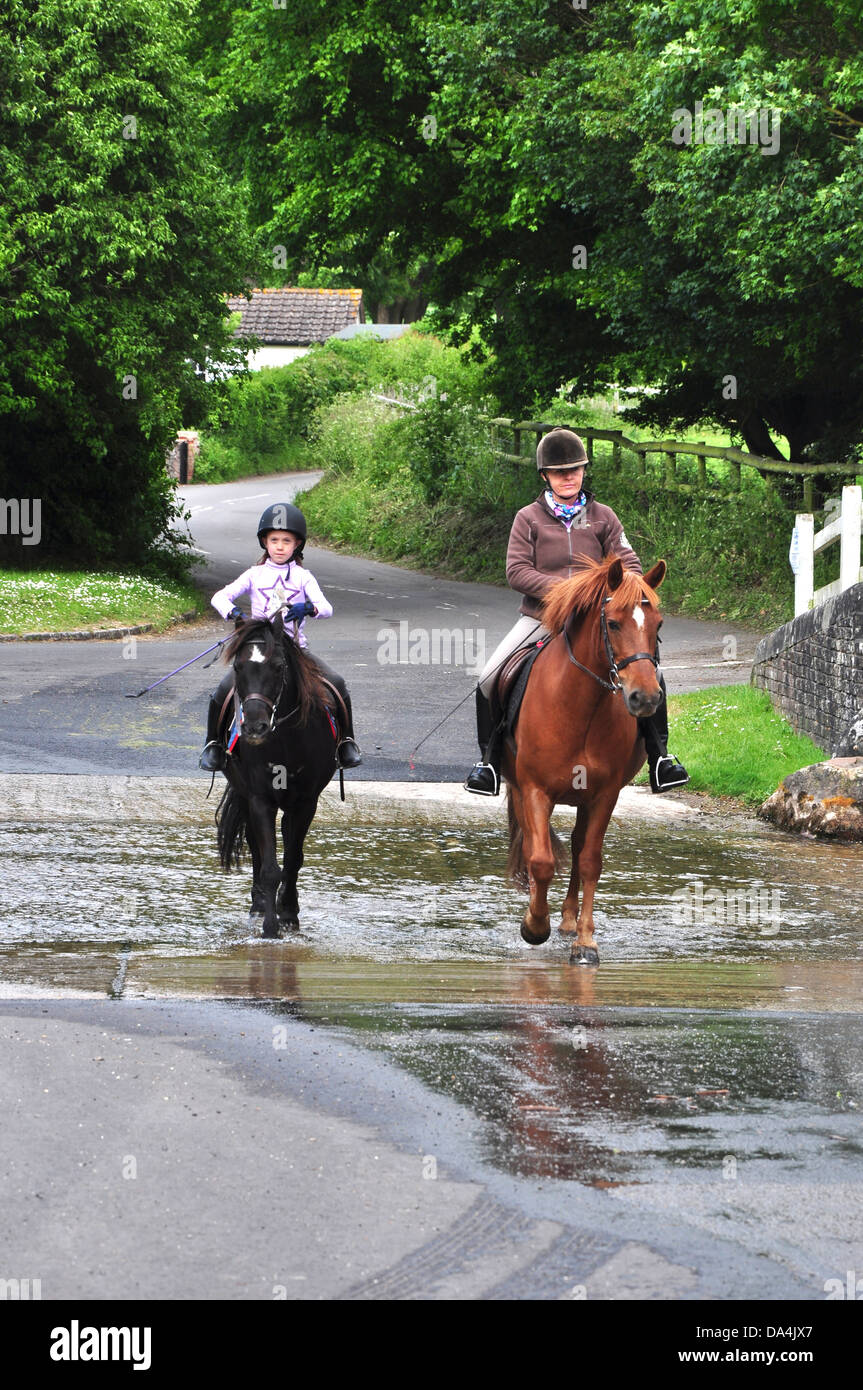 Horse riders crossing Tarrant Monkton ford Dorset UK Stock Photo