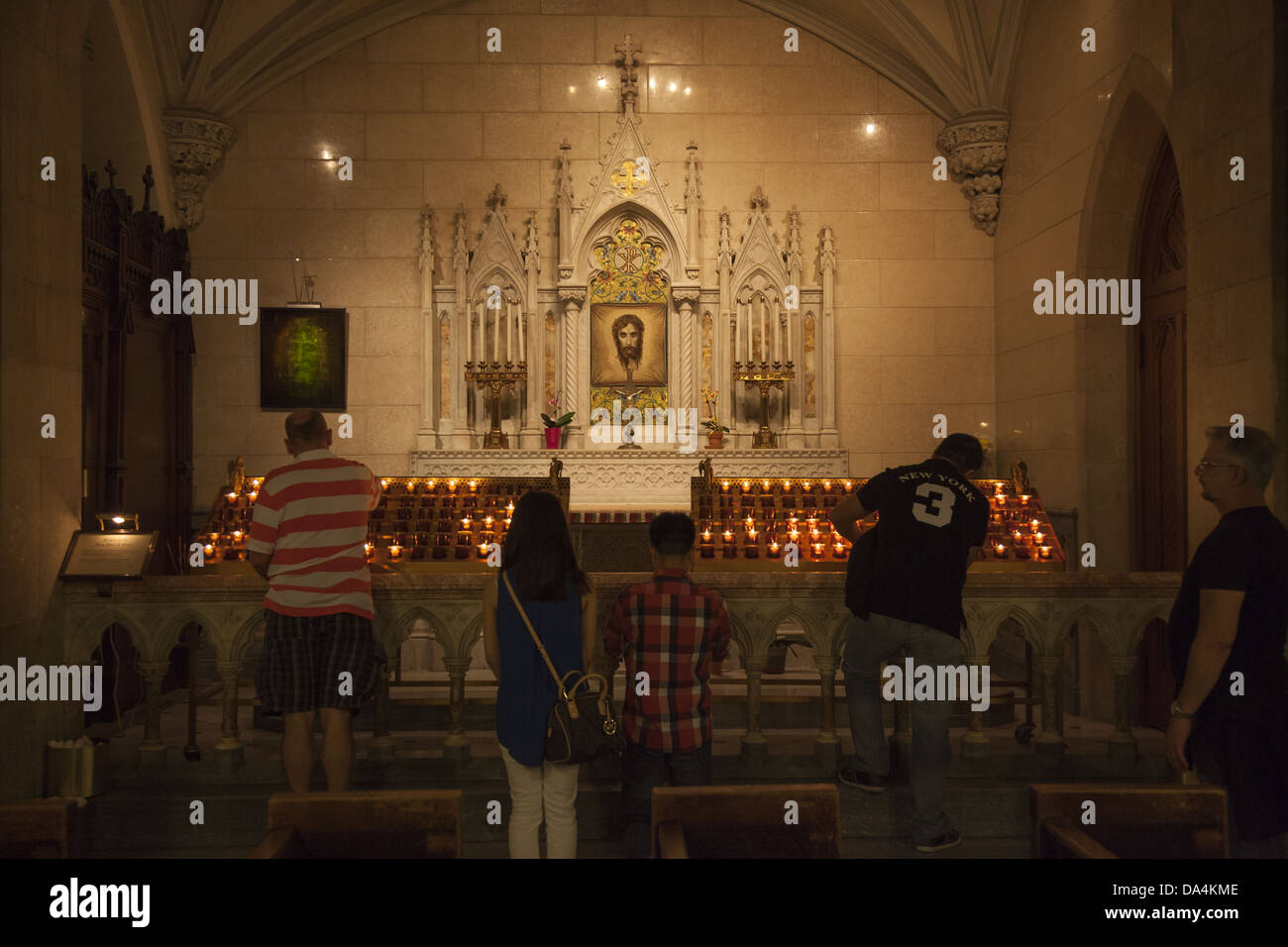 People praying, Side Alter, St.Patrick's Cathedral, Manhattan, NYC. Stock Photo