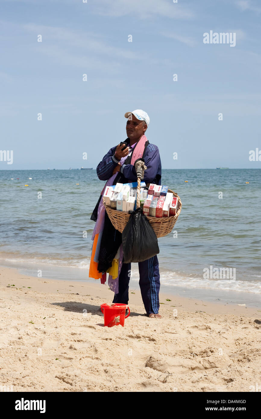Tunisian trader selling tobacco and shawls on the beach Stock Photo