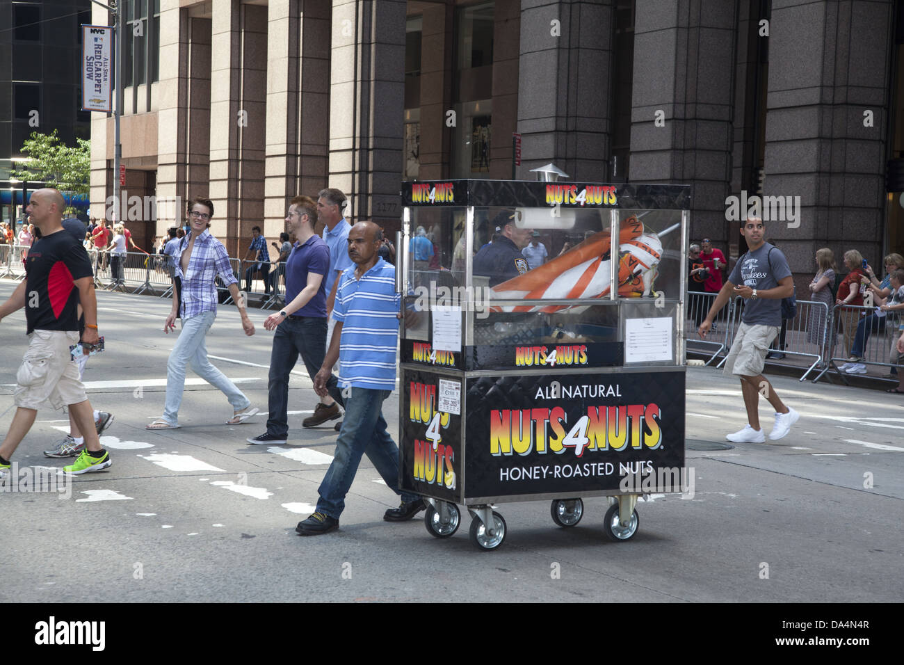Food street vendor crosses 6th Ave on his way to work in New York City. Stock Photo