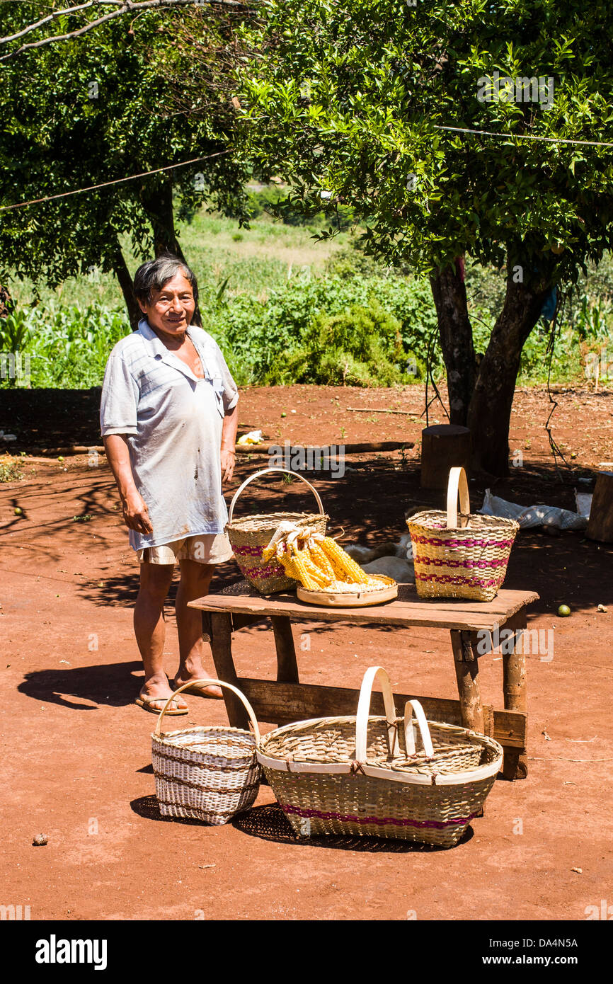 Member of Guarani ethnic group in Xapeco Indian Reserve and some examples of his handcraft work. Stock Photo