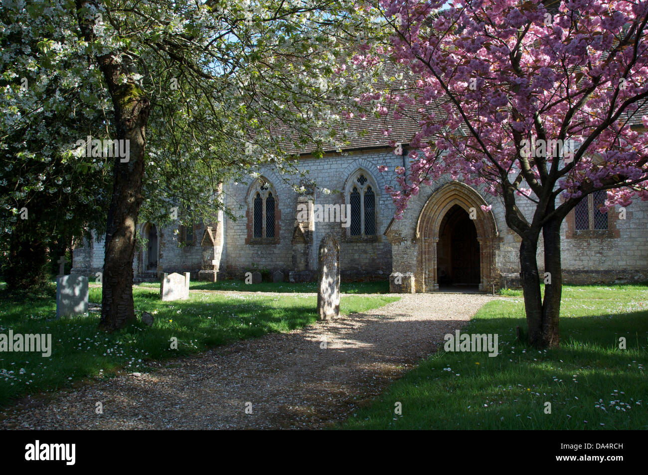 Springtime. The church of Saint John the Evangelist, in the Dorset village of Tincleton. The trees in the churchyard are in blossom. England, UK. Stock Photo