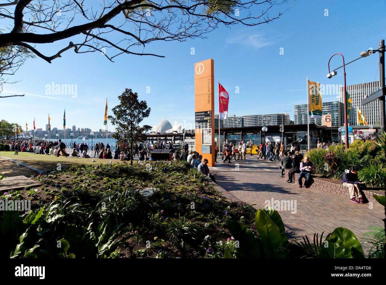 A view of Circular Quay from First Fleet Park, showing directional signage, banners and tourists. Stock Photo