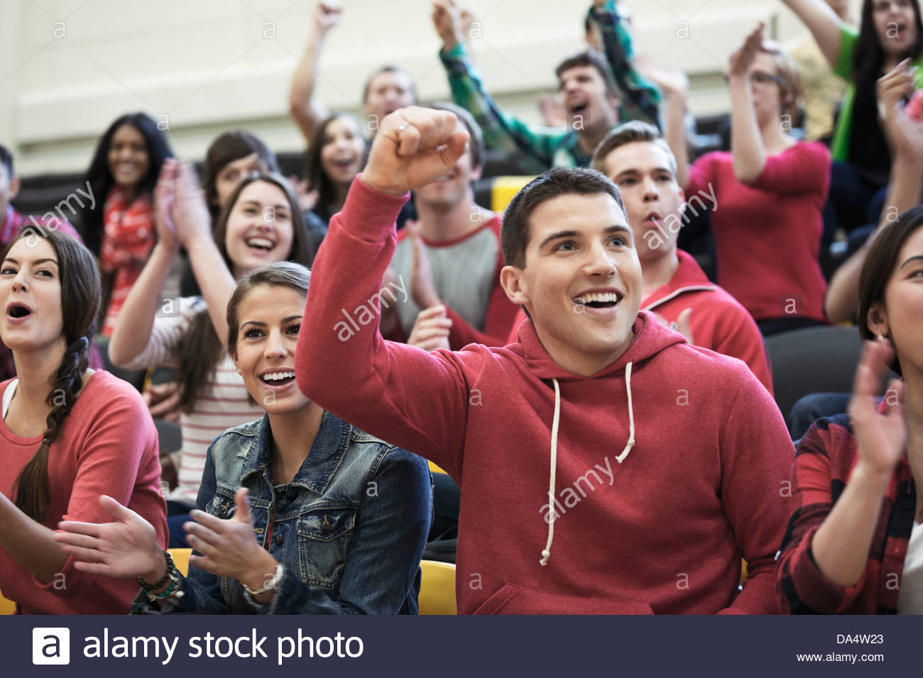 Large group of students cheering at college sporting event Stock Photo