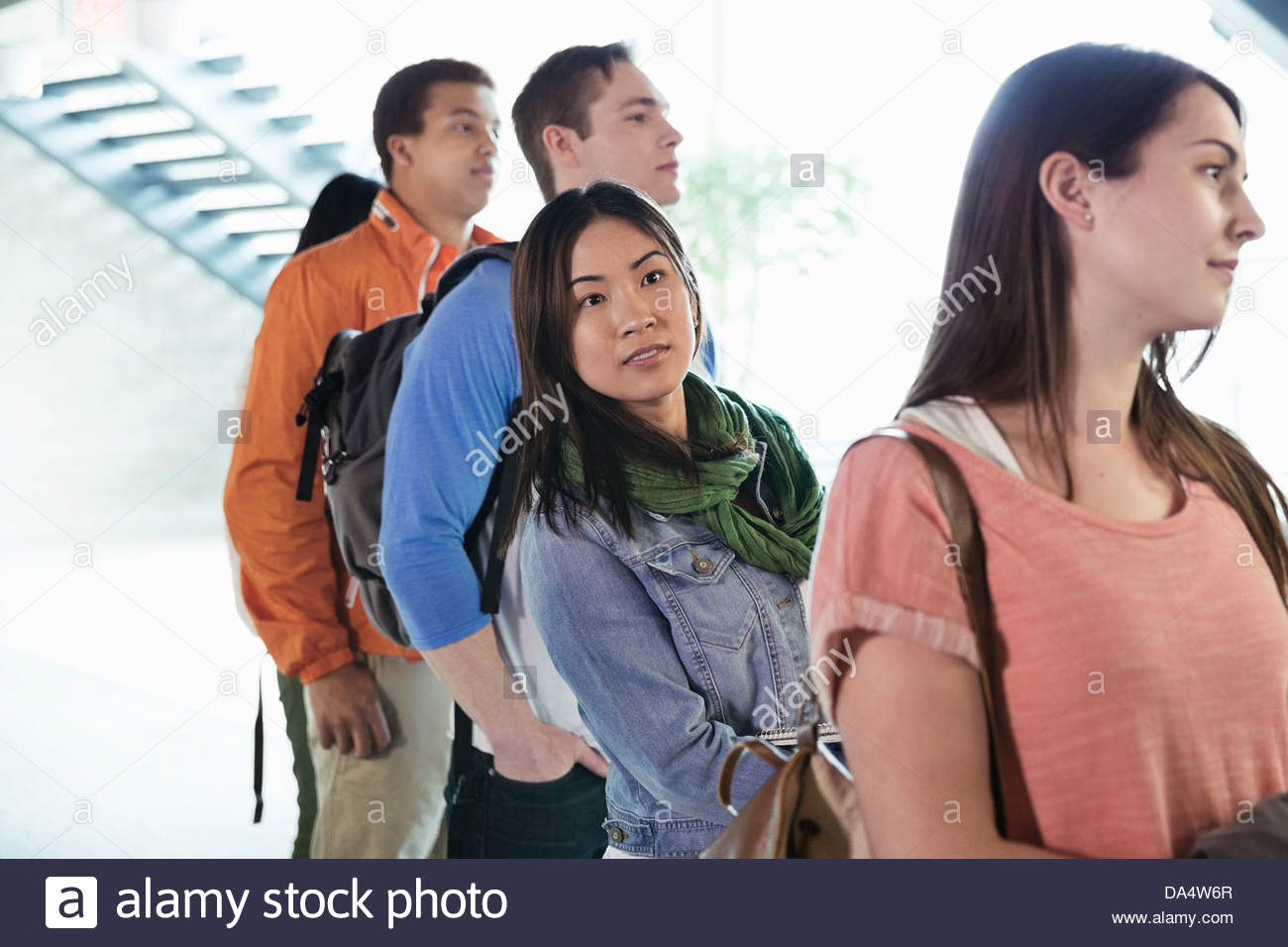 Group of students standing in line at college campus Stock Photo