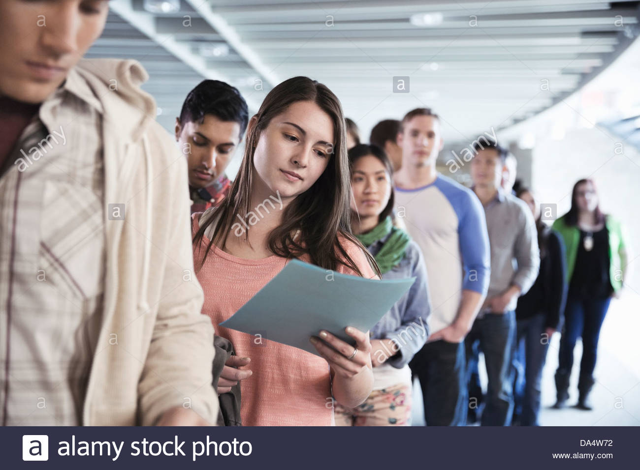Large group of students standing in line at college campus Stock Photo