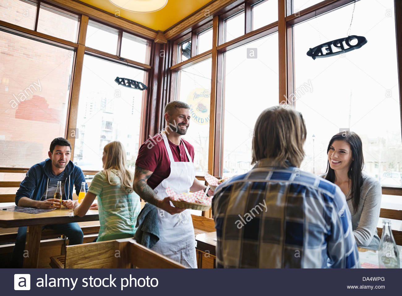 Male deli owner serving food to customers Stock Photo Alamy