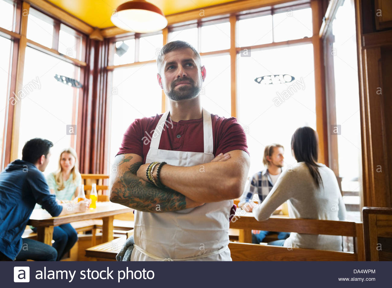 Male deli owner standing with arms crossed in restaurant Stock Photo