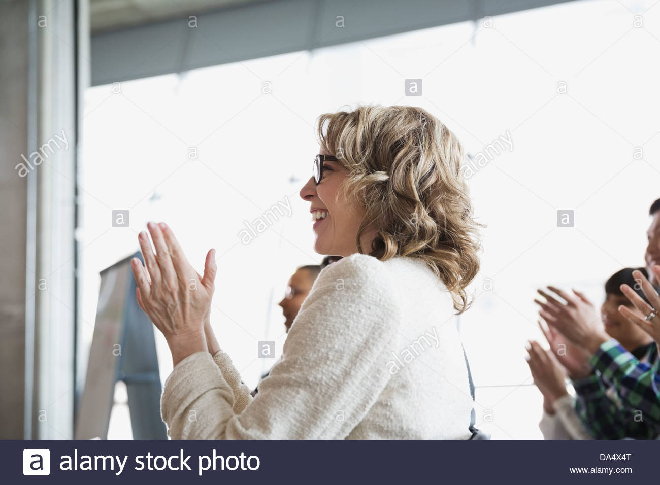 Businesswoman applauding presenter in office Stock Photo