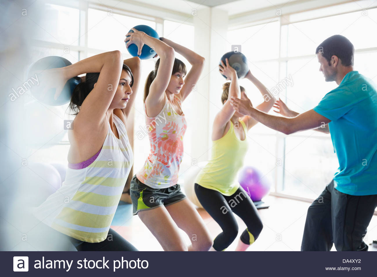Women using medicine balls in fitness class Stock Photo