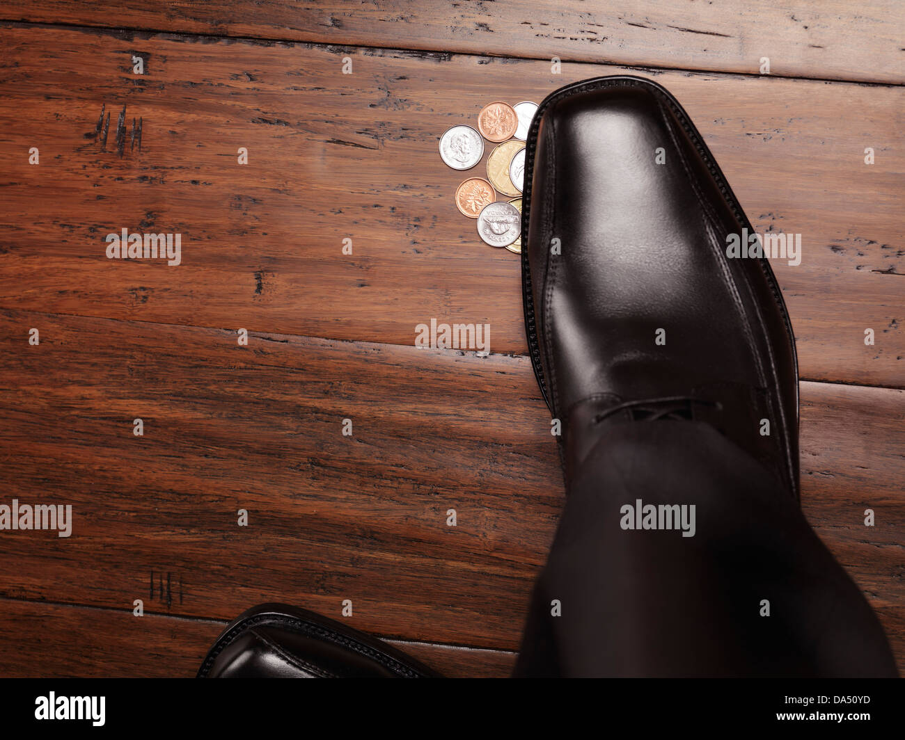Closeup of man shoe standing on coins, money found on the floor concept Stock Photo