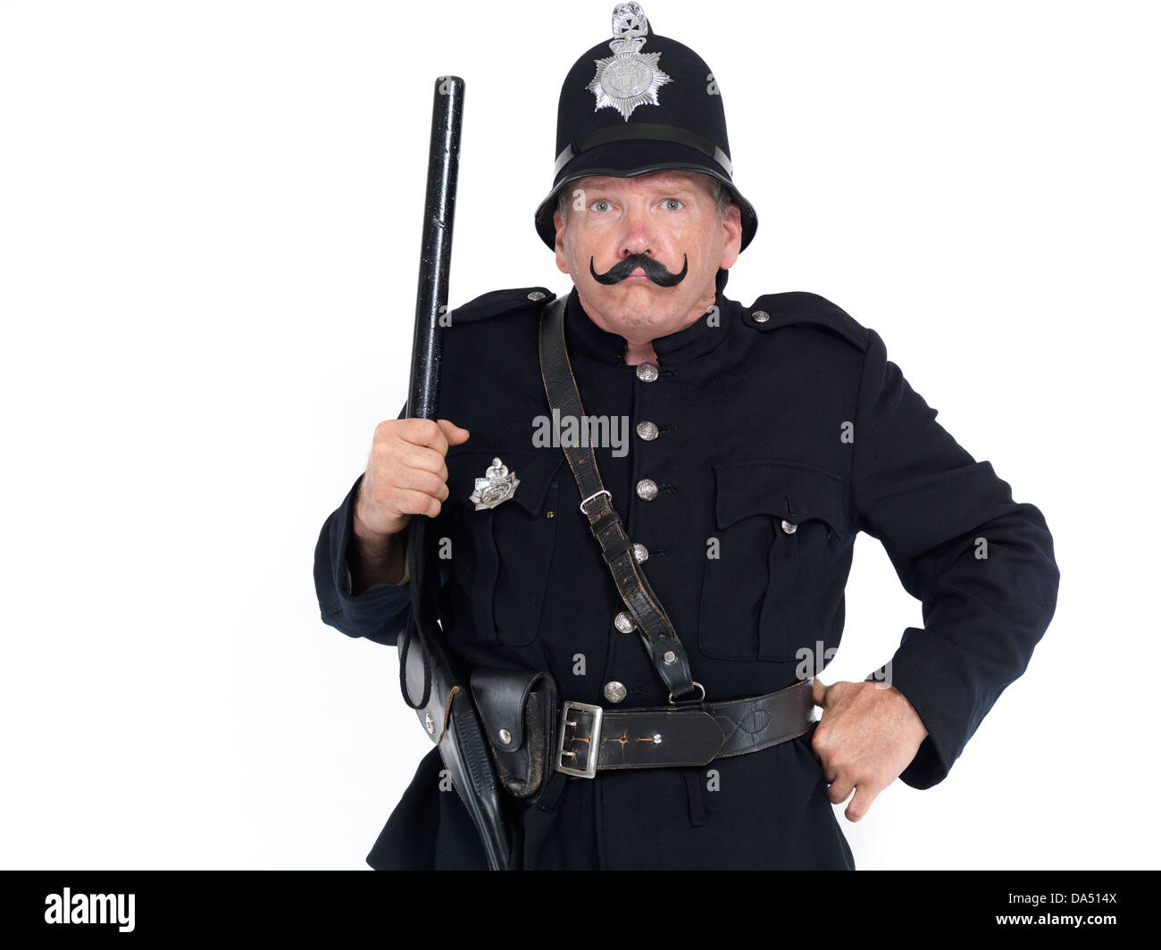 Humorous portrait of a keystone cop, vintage police officer with strict funny expression holding a baton. Isolated on white Stock Photo