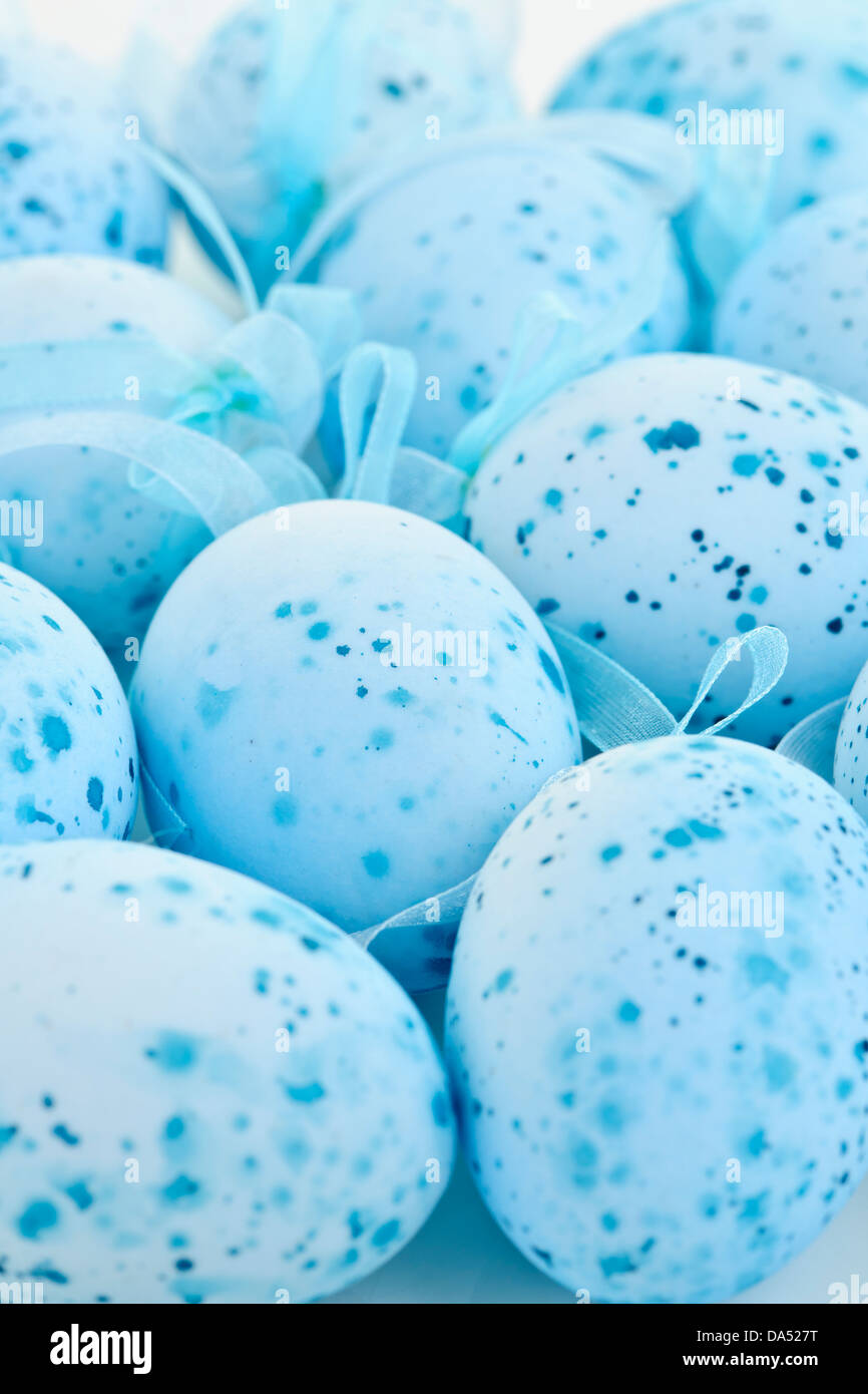 Pale blue speckled painted Easter eggs with ribbons Stock Photo