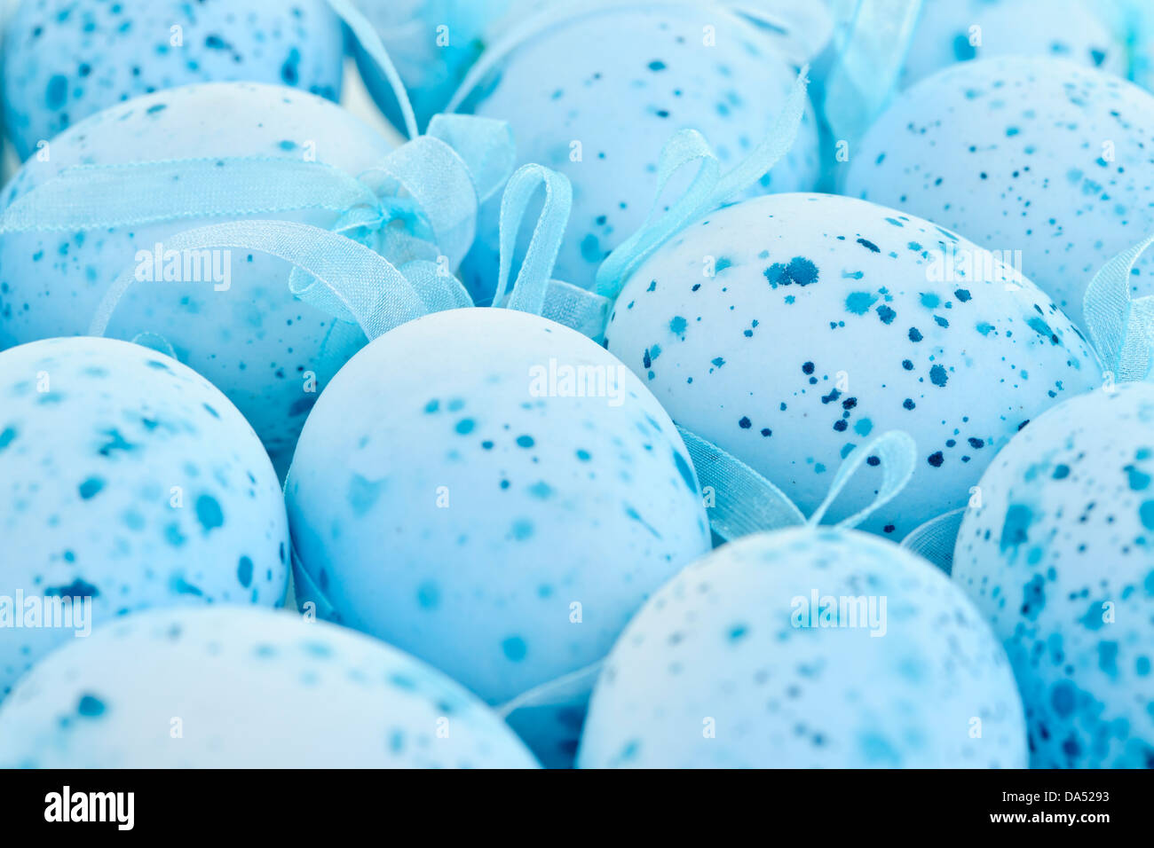 Pale blue speckled painted Easter eggs with ribbons Stock Photo