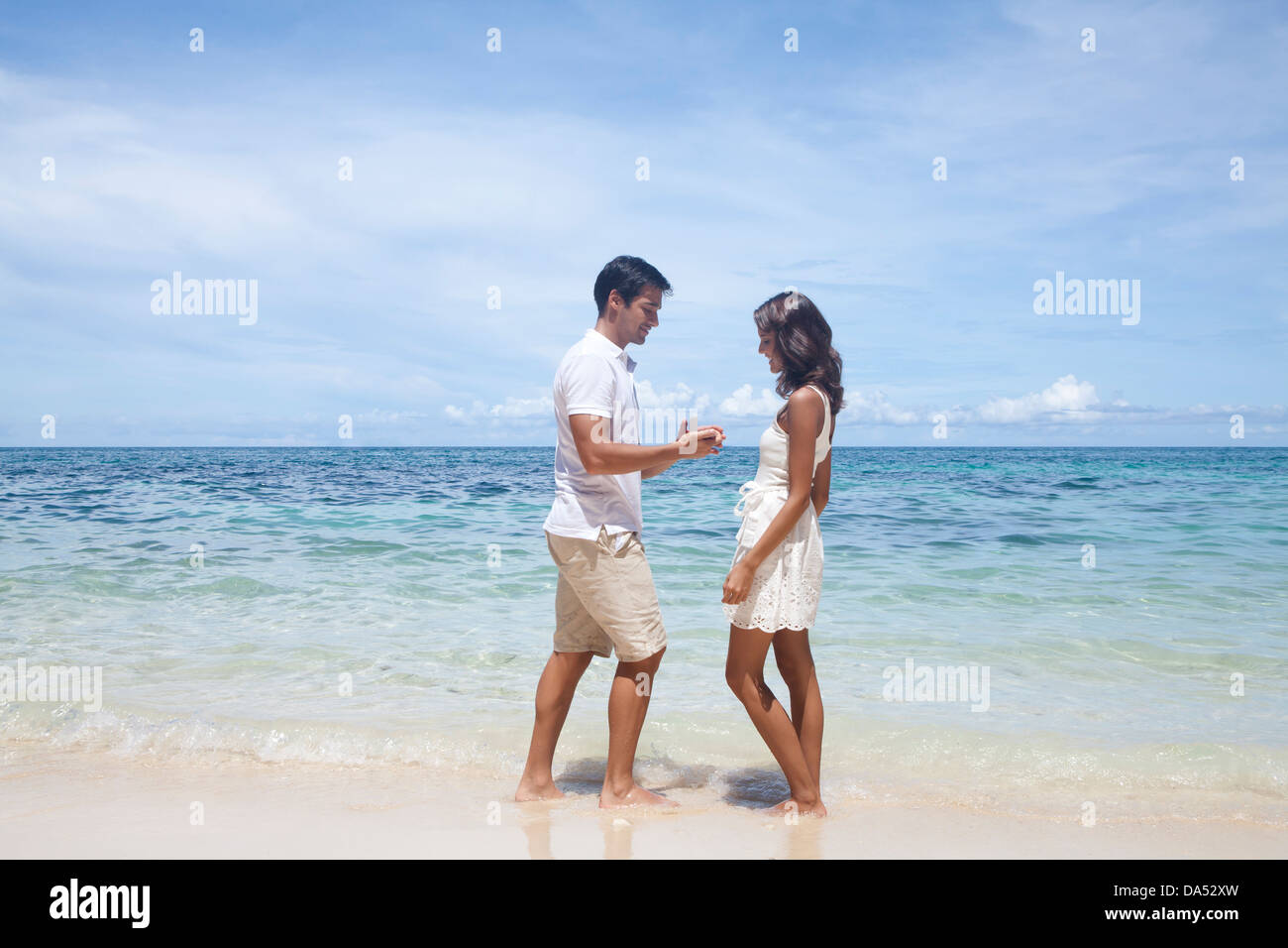 A young couple posing by the sea. Stock Photo