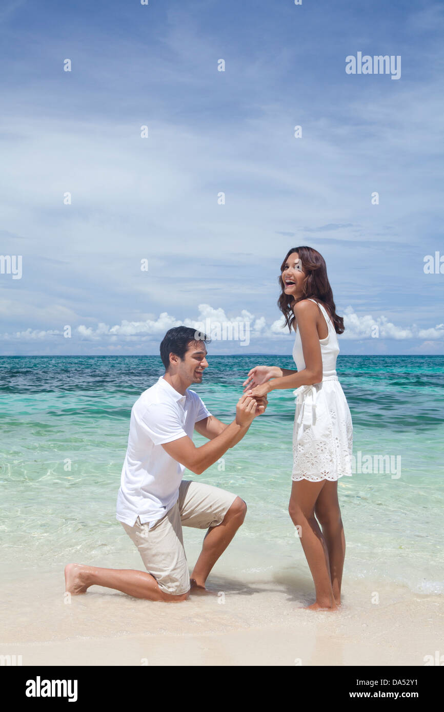 A young couple posing by the sea. Stock Photo