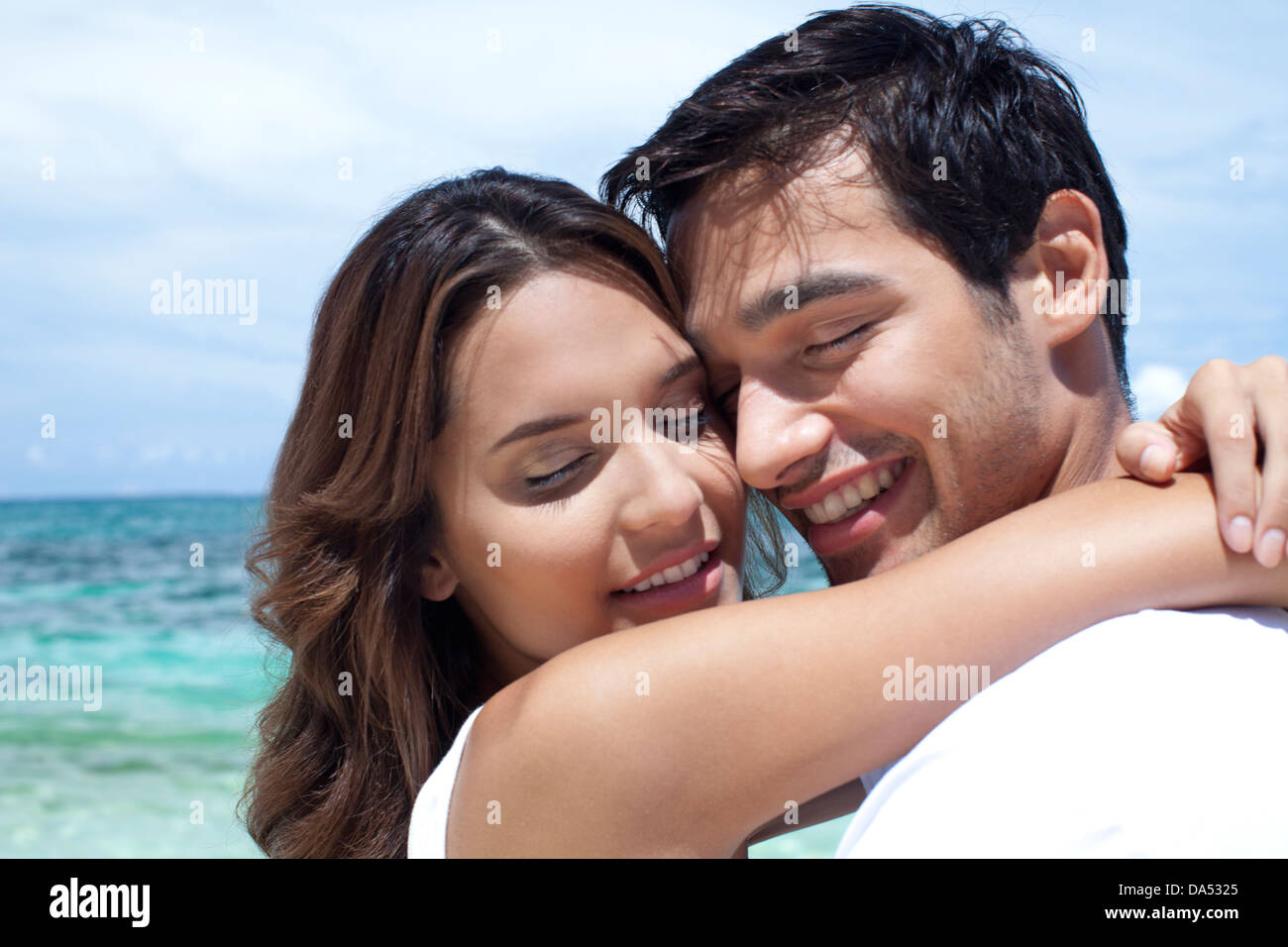 A young couple posing by the sea. Stock Photo