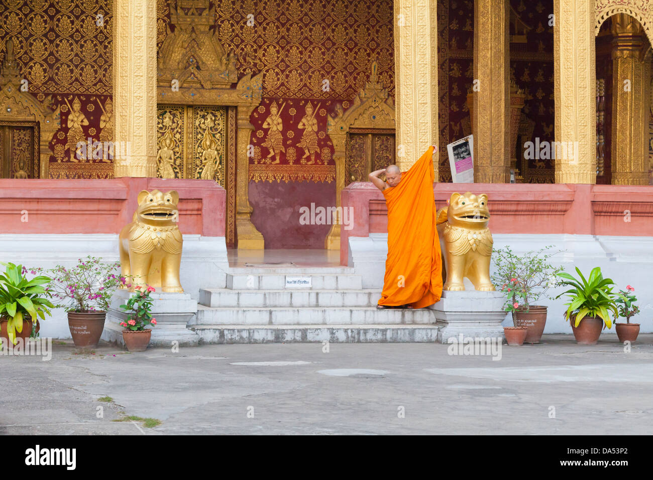 Buddhist monk folding his robes, Wat Saen temple, Luang Prabang, Laos Stock Photo