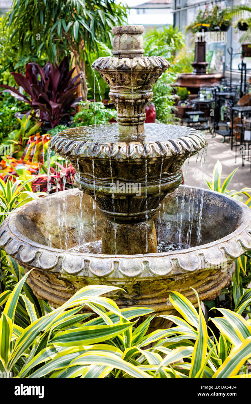 Cascading concrete fountain in garden nursery store with water flowing Stock Photo