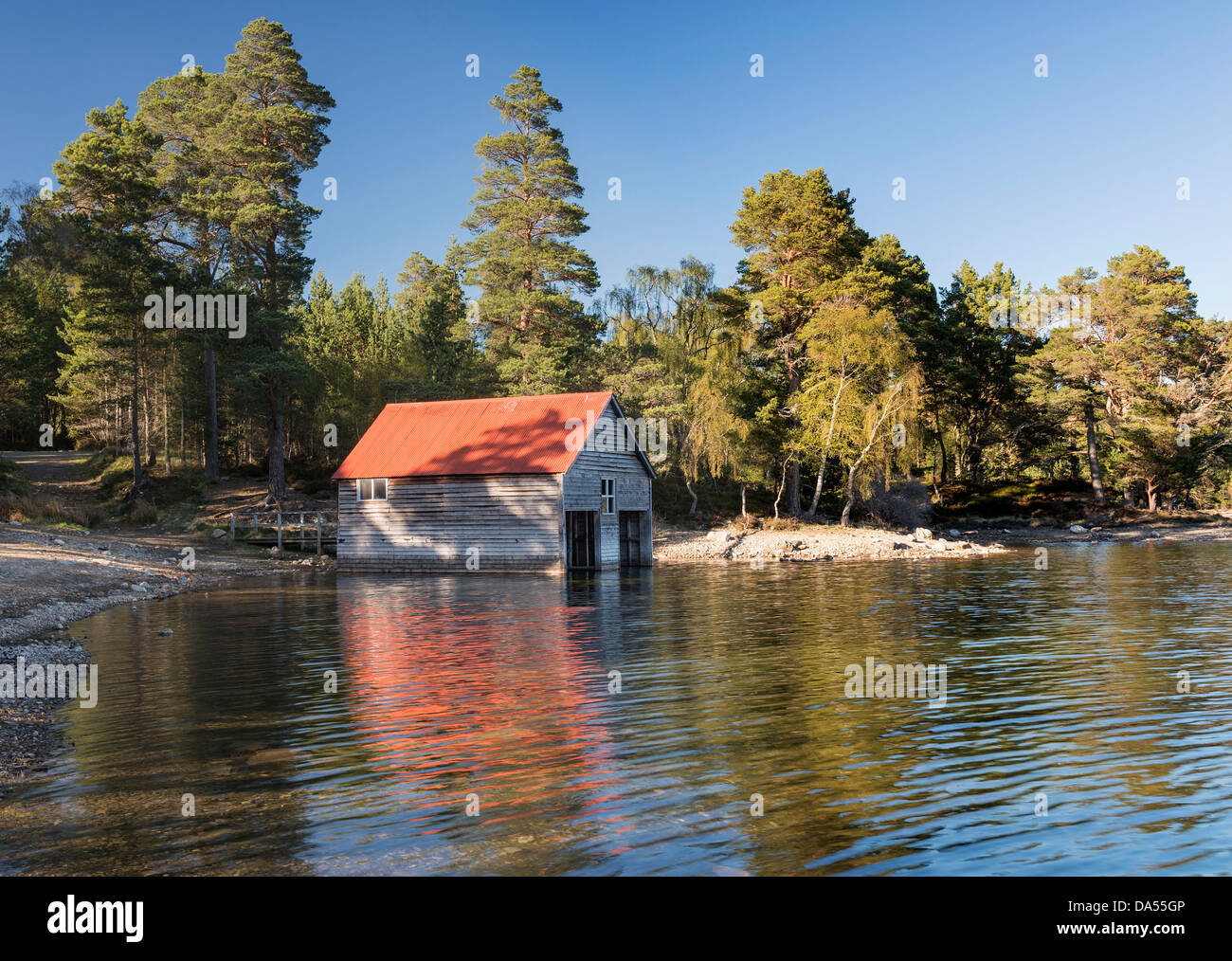 Dappled evening light on a boat house at Loch Vaa near Aviemore in the Cairngorms Stock Photo