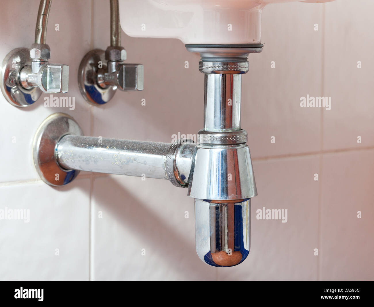 used metal sink siphon and drain closed up Stock Photo