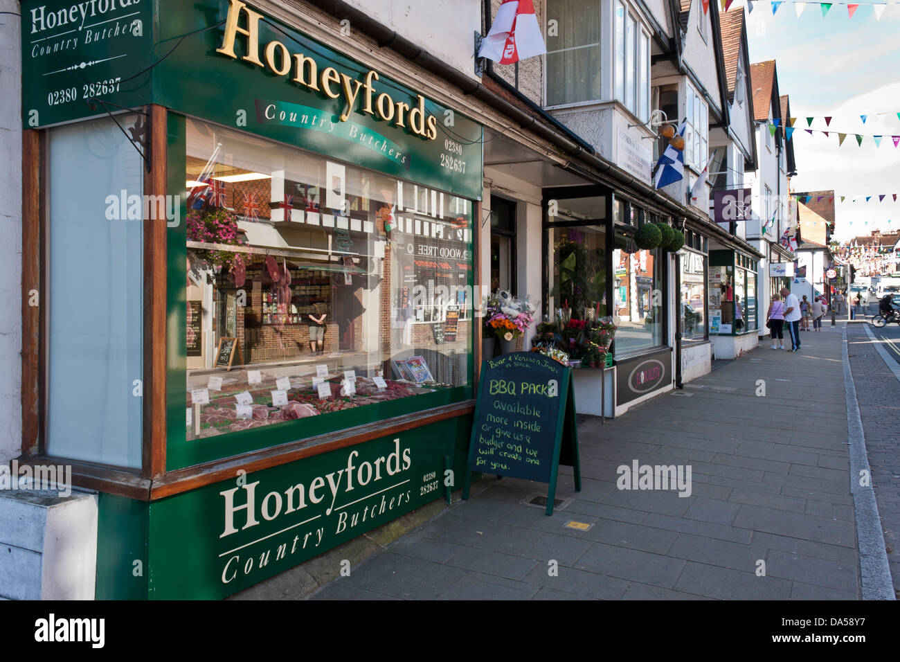 Butcher's shop window display in a small country town high street. Lyndhurst, Hampshire, England, GB, UK Stock Photo