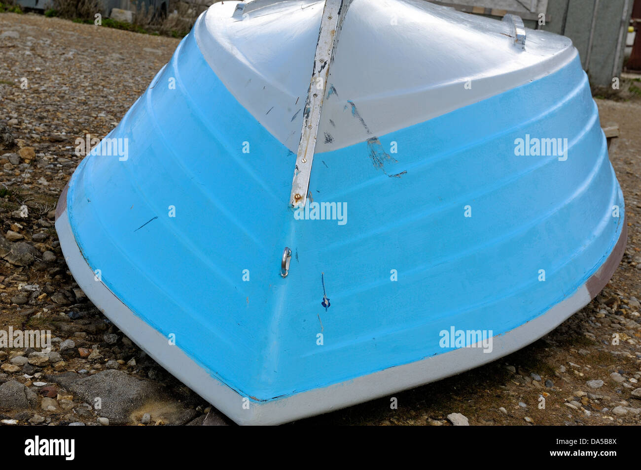 Blue rowing boat upside down on a beach Stock Photo