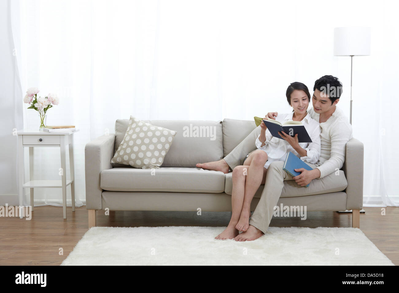 A young couple sitting on a couch. Stock Photo