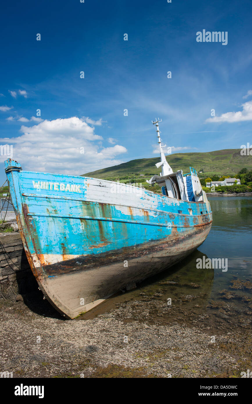 Old Fishing boat leaning against the harbour wall Caherciveen, County Kerry, Ireland Stock Photo