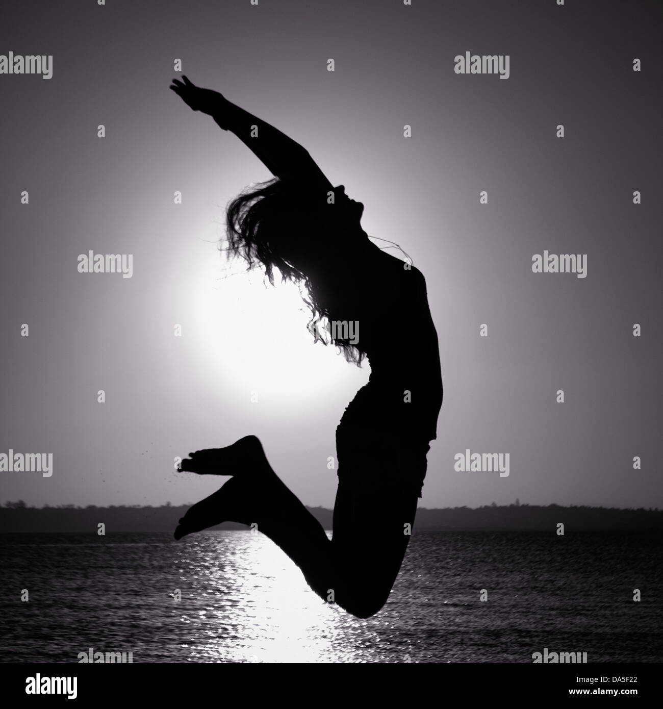 A silhouette of a jumping woman Stock Photo