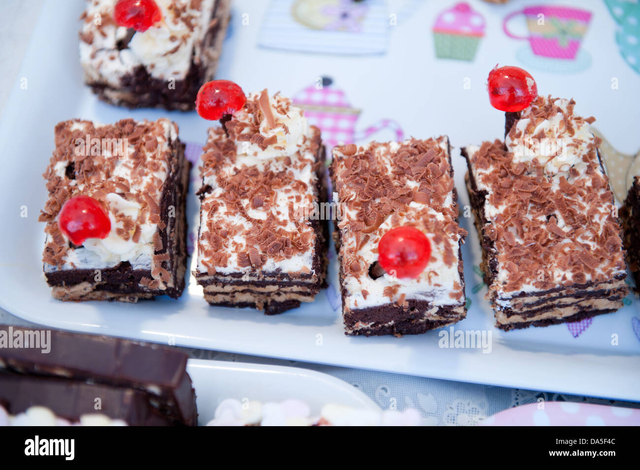 Black Forest Chocolate Gateau Slices With Cream Icing Chocolate Shavings And Red Glace Cherry On A Colourful Tray Stock Photo Alamy
