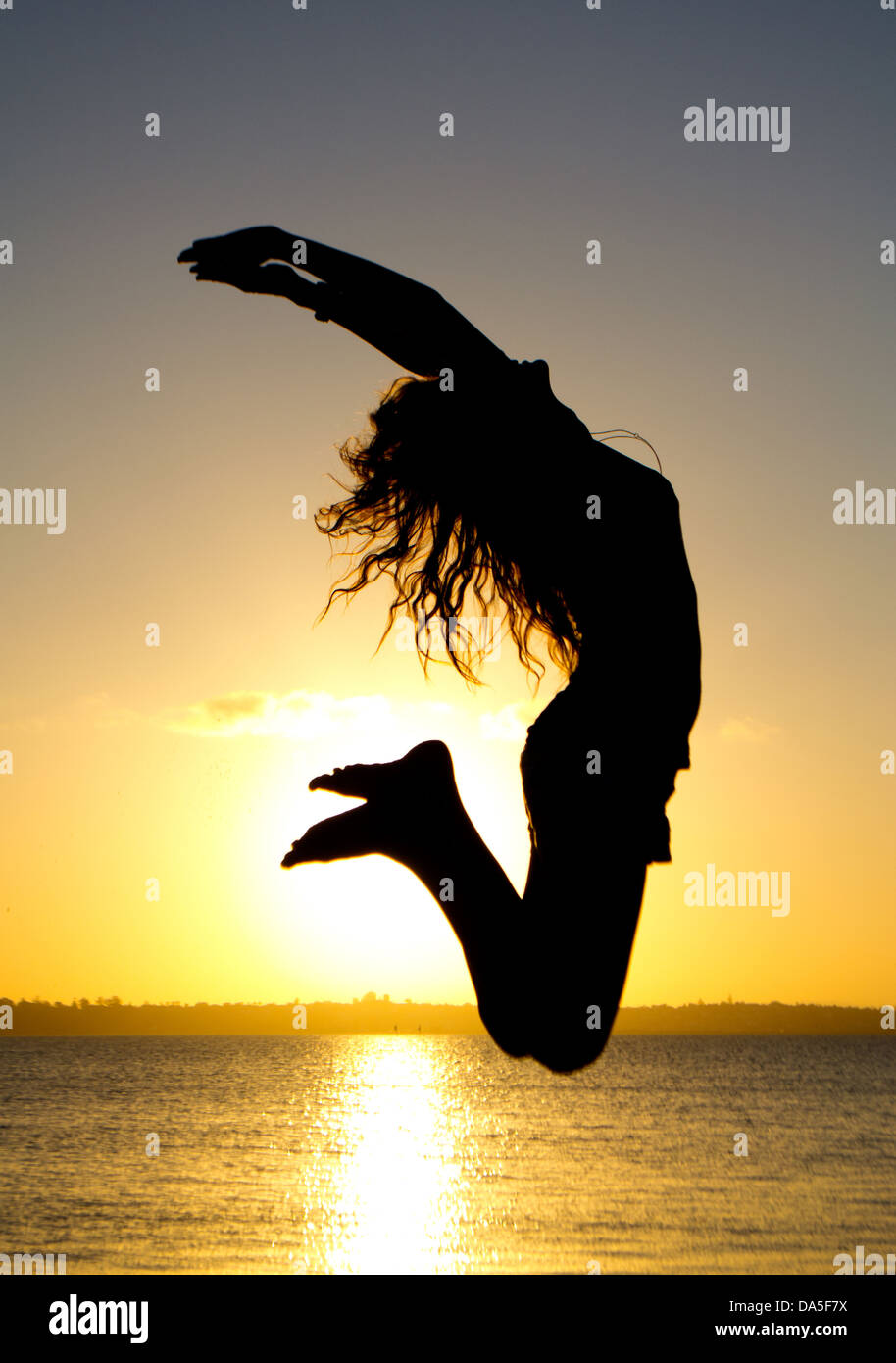 A silhouette of a jumping woman Stock Photo