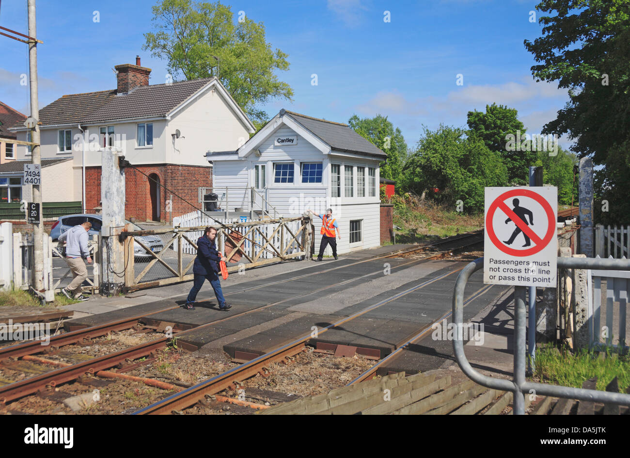 A gate keeper opening level crossing gates by Cantley railway station, Norfolk, England, United Kingdom. Stock Photo